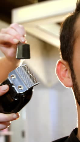 hombre recortando su cabello con un cortador