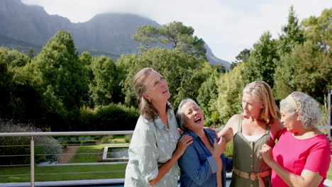 senior diverse group of women share a laugh outdoors, with copy space