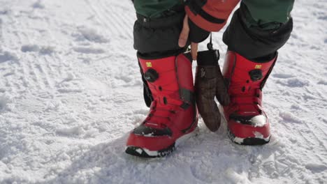 preparing tightening snowboarding boots before snowboarding