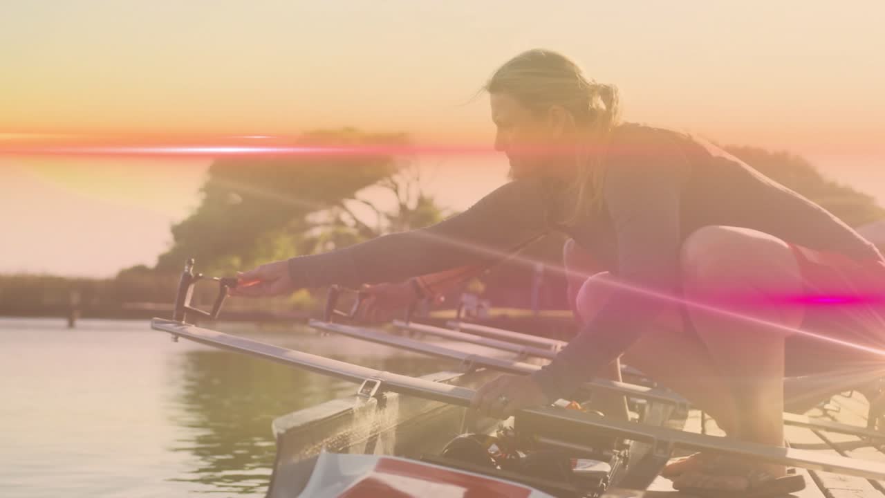 sun rising causing lens flare drifting frame as sports rower kneeling aligning oarlocks for rowing