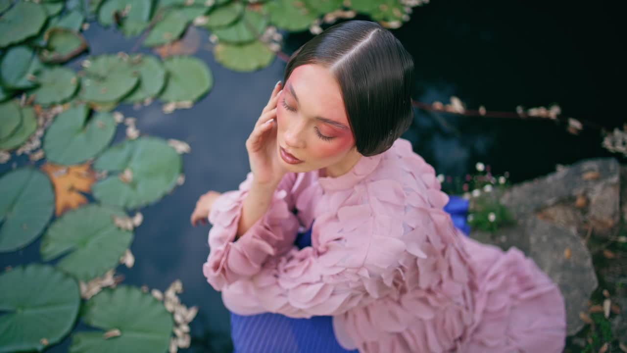 웅장한 여자가 앉아있는 호수 인 수리리 가까이. 신비로운 소녀 포즈