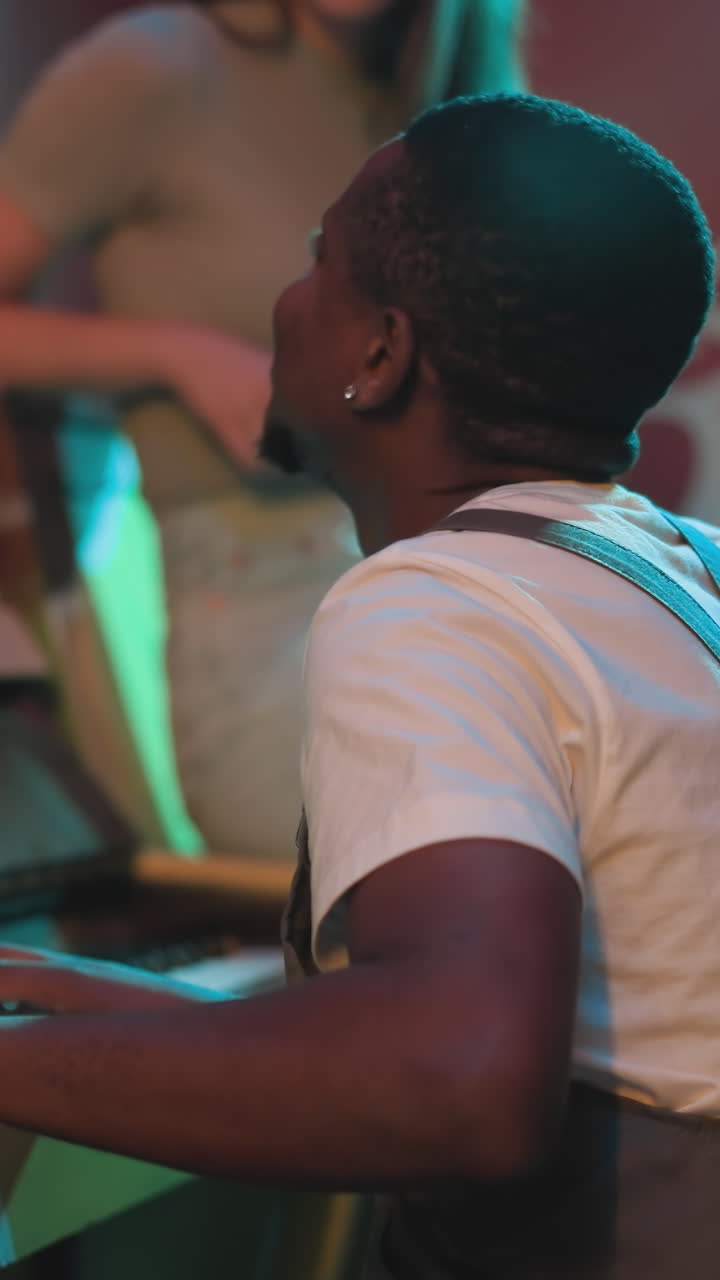 Positive pianist plays music to impress woman at party. African American musician performs melody while girlfriend listens in night club. Musical show