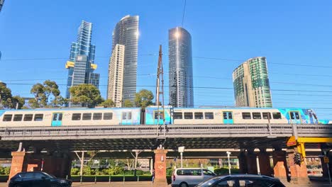 train travels over bridge with city skyline