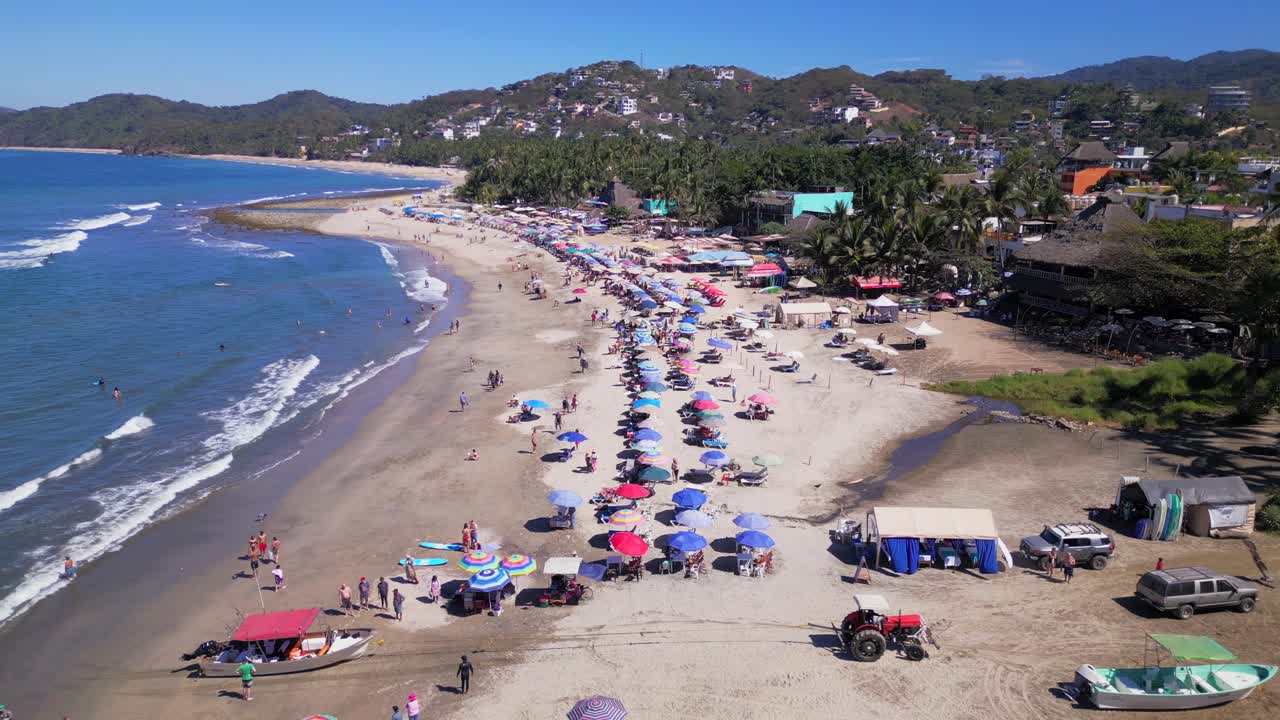 un dron vuela por encima de un tractor tirando de un bote fuera del océano en sayulita méxico