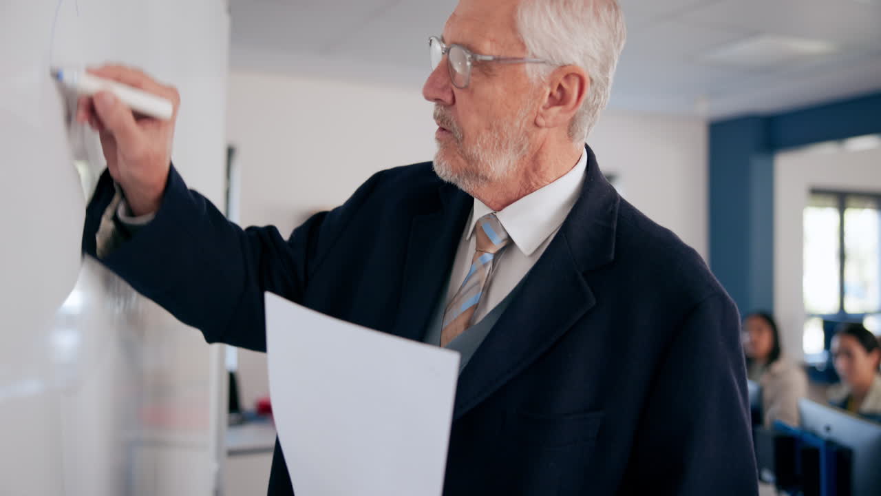A teacher writing on a whiteboard in a classroom