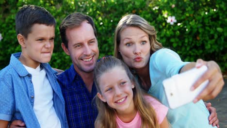 familia feliz tomando una selfie en el teléfono móvil en el parque