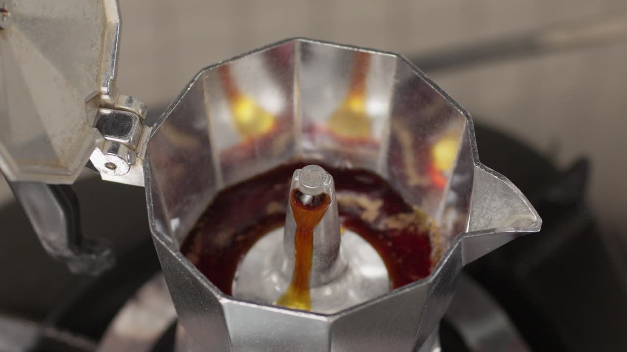 Fresh Coffee Brews And Pours Out Through Spout Of Moka Pot. closeup, slow motion