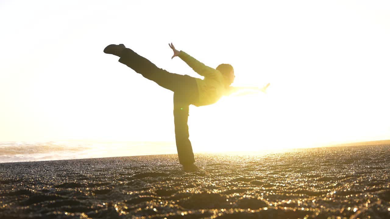 Donna che pratica lo yoga su una spiaggia al tramonto