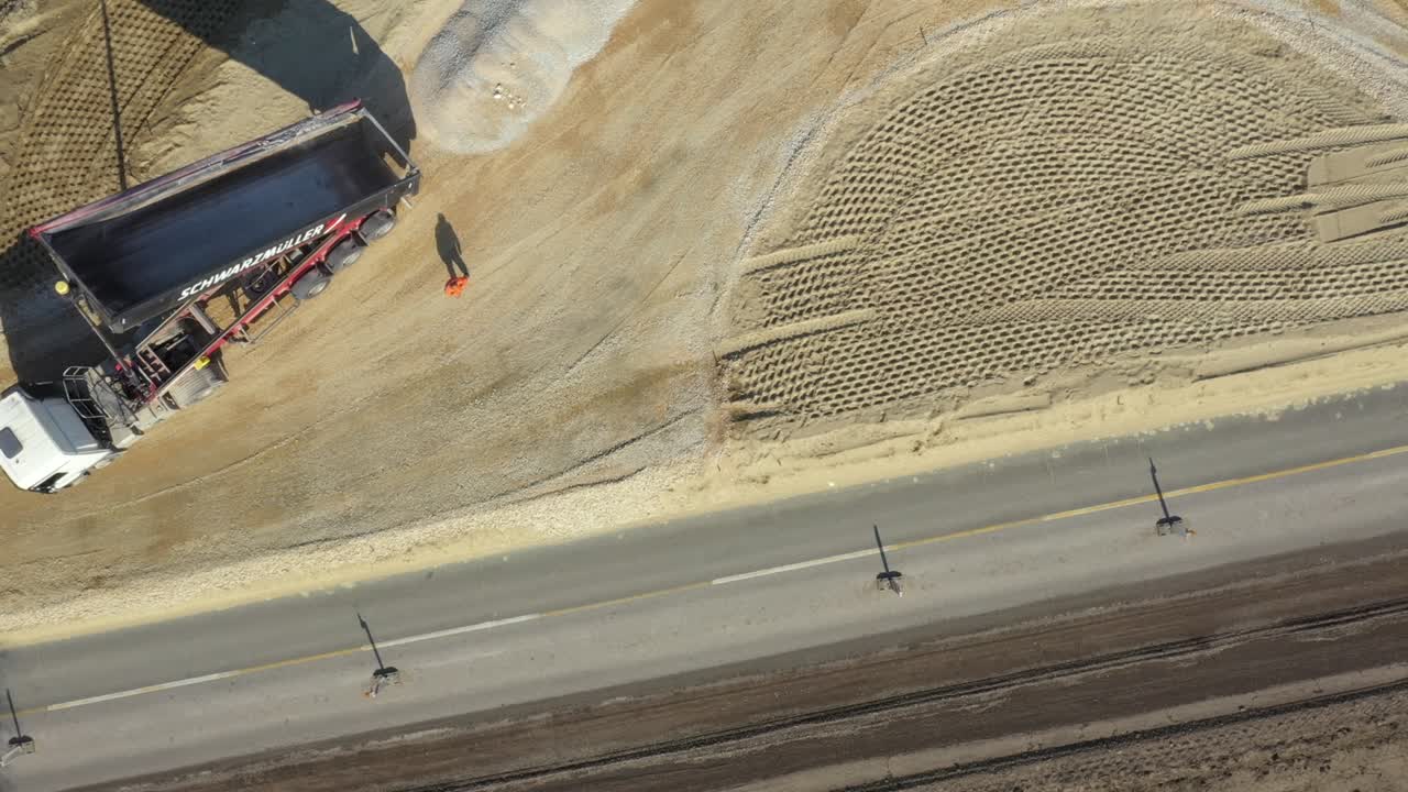 vista aérea en el camión de descarga está descargando grava del remolque sobre el sitio de construcción para la nueva rotonda de tráfico