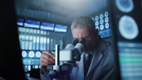 científico de investigación médica senior mirando bajo el microscopio en el laboratorio. neurólogo resolviendo rompecabezas de la mente y el cerebro. en el laboratorio con múltiples pantallas que muestran imágenes de escaneo cerebral de resonancia magnética o ct.