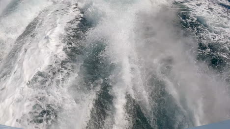 espuma de mar de agua blanca tras una lancha en el agua del océano - incline hacia arriba para revelar el horizonte pacífico en cámara lenta
