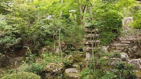 Hand-Held-Shot-of-Japanese-Green-Lush-Temple-Garden-with-Stones-and-Native-Trees-in-Zen-Atmosphere