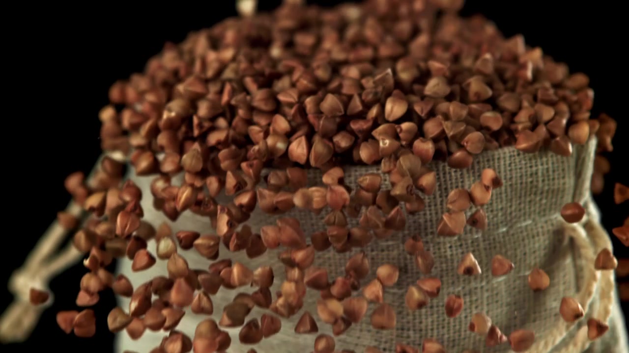 Buckwheat Grains Falling into a Burlap Sack in Slow Motion