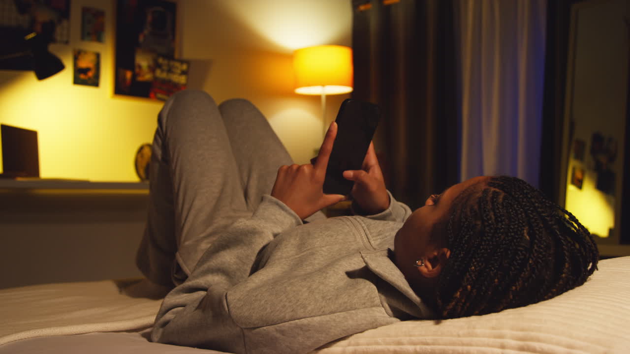 Teen Girl Using Phone in Bedroom at Night