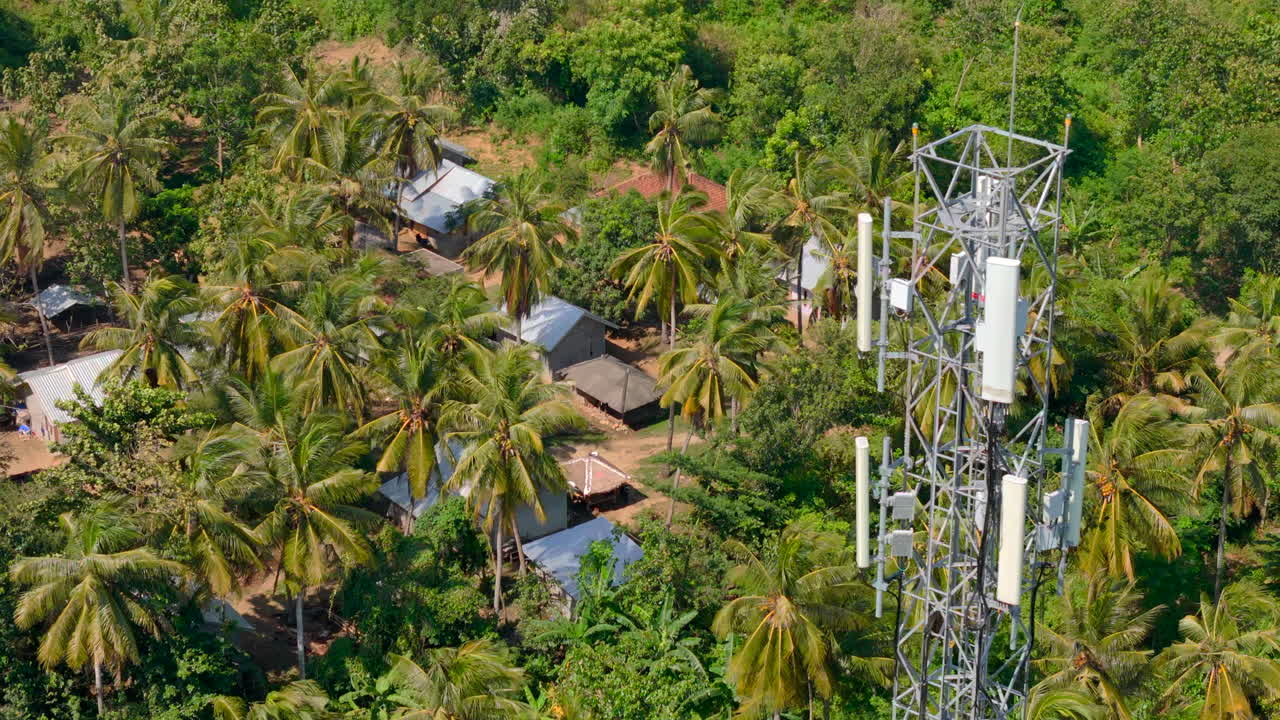 una torre de telefonía celular se levanta en medio de exuberantes palmeras en la zona rural de lombok, indonesia