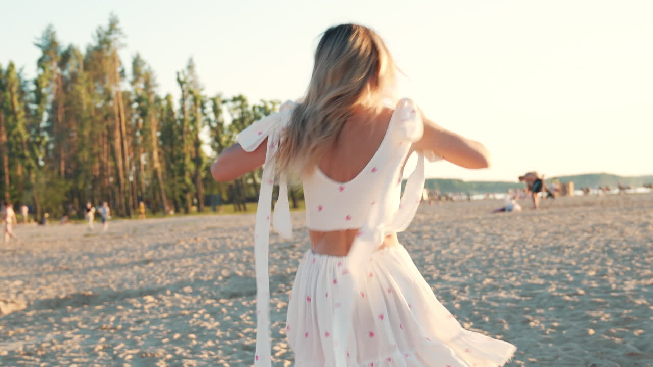 해가 지면 해변에서 춤을 추는 여자