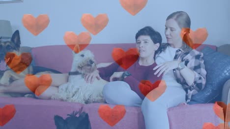 animación de iconos de corazón rojo sobre pareja de mujeres con perros mascotas.