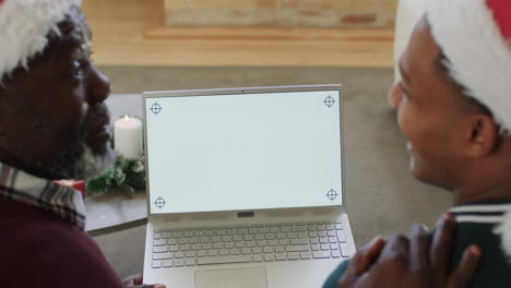 feliz padre y hijo afroamericanos teniendo navidad llamada de video portátil, espacio de copia, cámara lenta