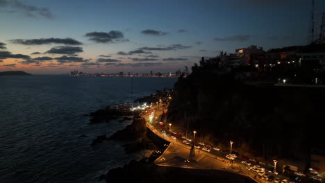 Aerial-view-backward-traffic-on-the-coast-of-Mazatlan,-dusk-in-Mexico