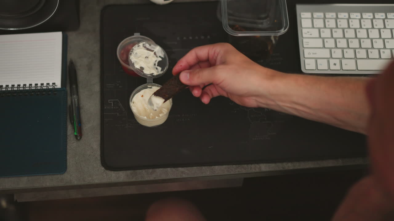 Person eating a snack at a desk