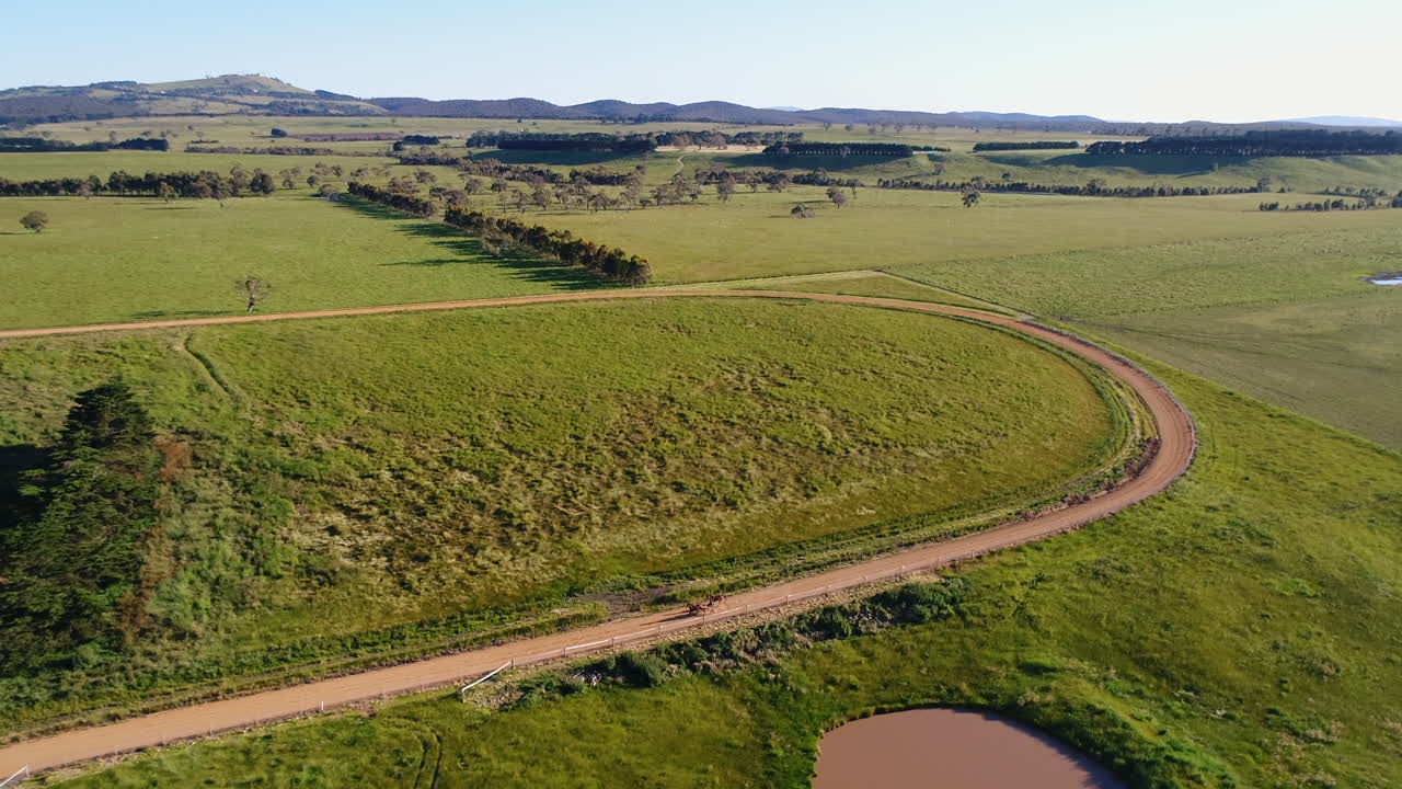 무인 항공기가 트랙에서 하네스 경마를 멀리 당깁니다.