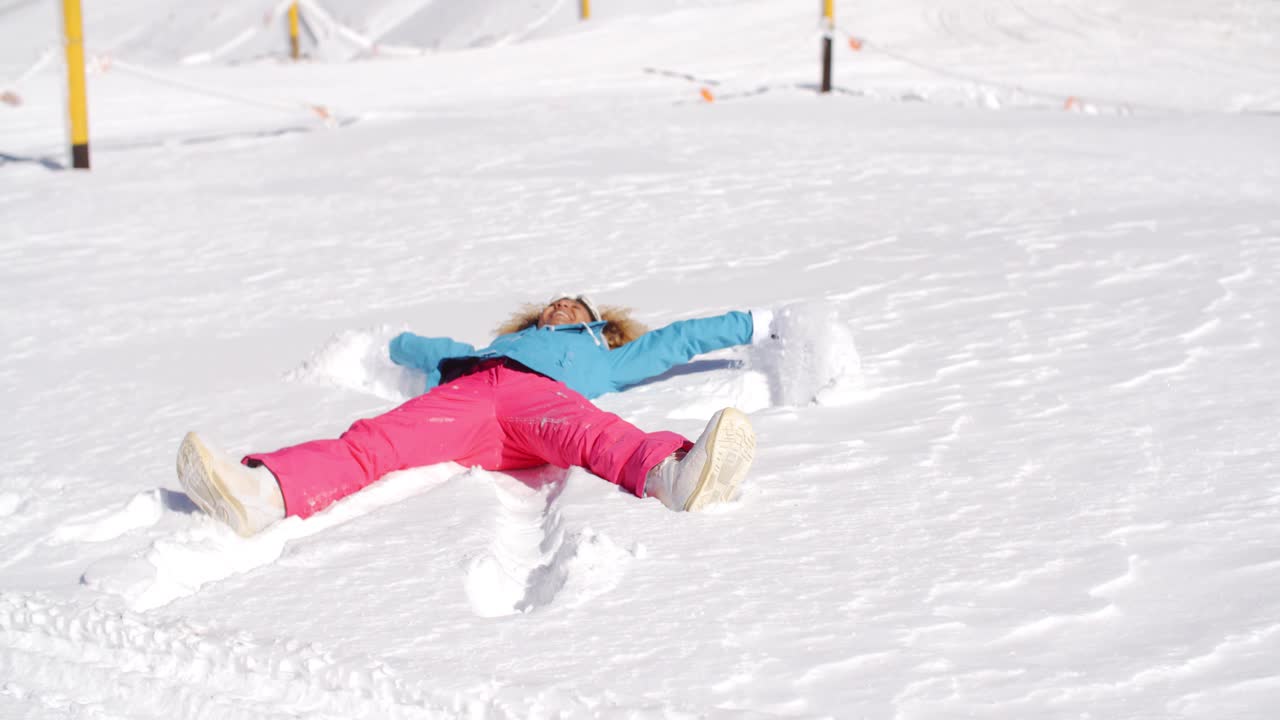 joven haciendo un ángel de nieve en nieve blanca
