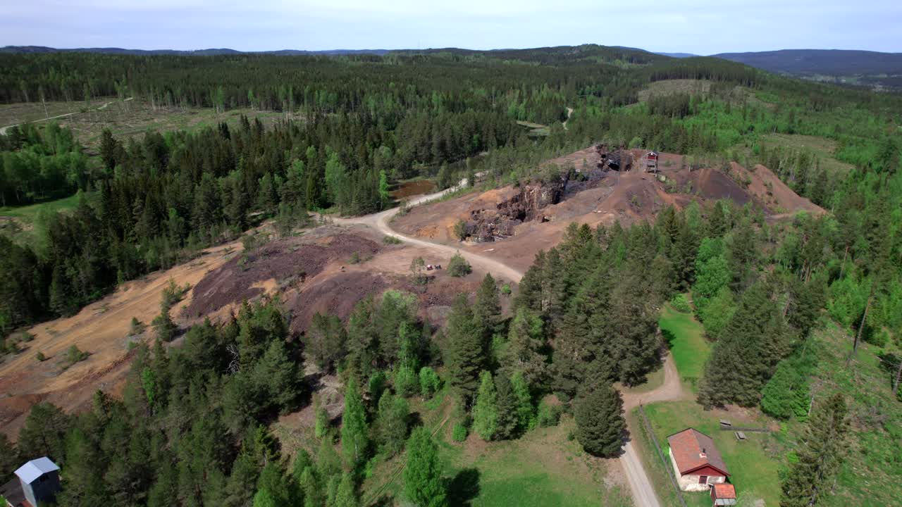 кружащий над заброшенной шахтой в бергслагене и обширным лесным ландшафтом, индустриальное наследие, аэрофотосъемка