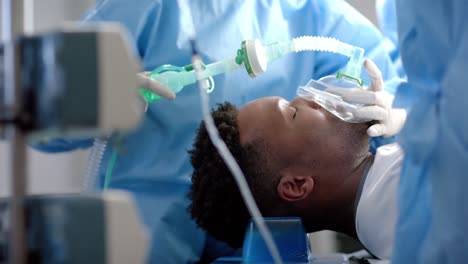 diverse surgeons giving anesthesia to patient in operating theatre, slow motion