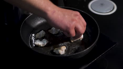 chef freyendo pedazos de pollo en una sartén