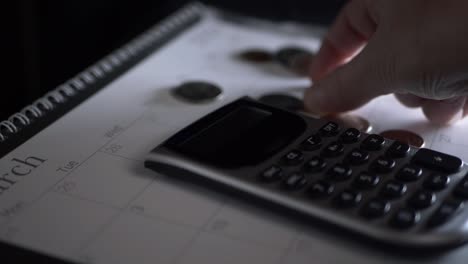 Hand with calculator counting money close up panning shot