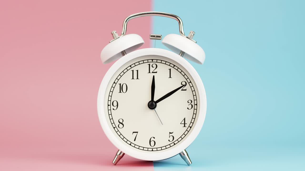 Alarm clock isolated on a pink blue background.