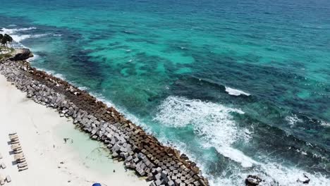 Waves breaking on breakwater of Cancun tropical sandy beach, Mexico