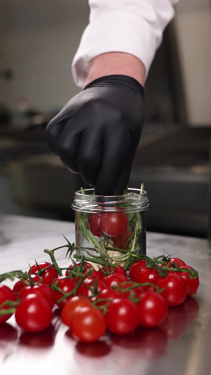 요리사 가 항아리 에 체리 토마토 를 준비 하고 있다