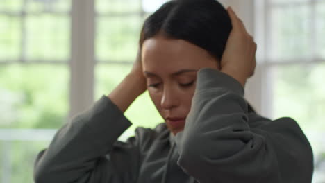 close up on face of anxious woman sitting indoors on sofa worried about cost of living crisis and paying bills 1