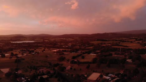 aerial shot of the orange glow of sunset over farmland in rural victoria australia