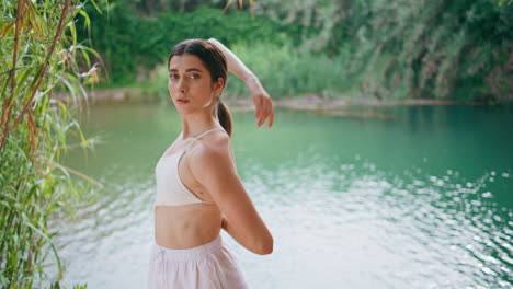 yoga woman connecting hands turquoise water nature portrait. girl looking camera