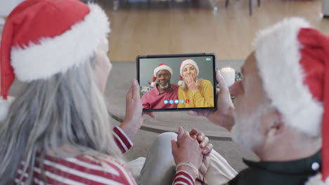 Happy-diverse-senior-couples-having-christmas-tablet-video-call,-slow-motion