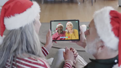 parejas de ancianos felices con tabletas de navidad llamada de video, cámara lenta