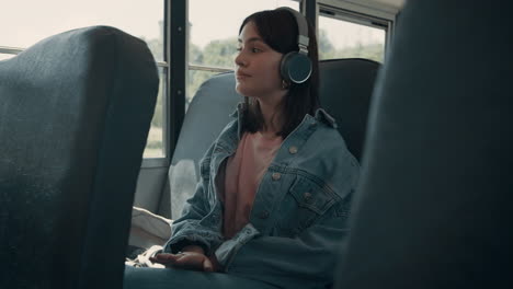 Girl-teenager-enjoying-listening-music-looking-window-vehicle-transport-close-up