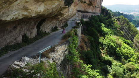 woman walking on a road along a cliff