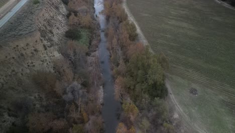 vista aérea capturando el río arroyo seco que fluye a través de un paisaje sereno de greenfield, california, bordeado por una carretera y campos agrícolas