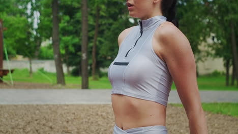 a female athlete performs reverse exercises on a bench in a park in slow motion. beautiful woman playing sports in the park