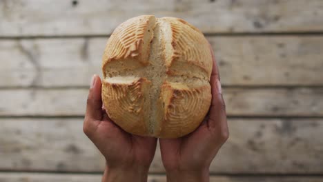 Video-Von-Brot-In-Händen-Auf-Einer-Holzarbeitsplatte,-Von-Oben-Gesehen