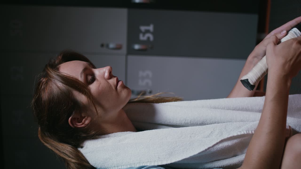 mujer descansando después de un partido de tenis en el vestuario