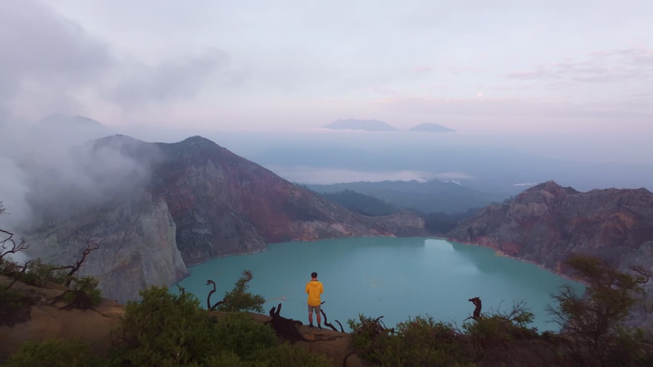 Cahaya fajar berkabut di danau asam Ijen dan puncak-puncak gunung berapi, Indonesia