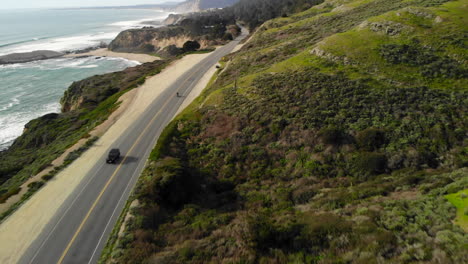 aerial of motorcyclist riding on california coast highway one