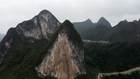 Asian-karst-mountains-on-overcast-day,-aerial-arc-shot