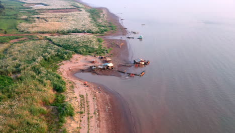 Aerial-drone-footage-flying-turning-over-a-fisherman-house-on-the-Mekong-shore-near-Phnom-Penh-in-Cambodia