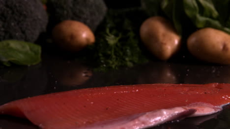 trout fillet falling in front of vegetable selection