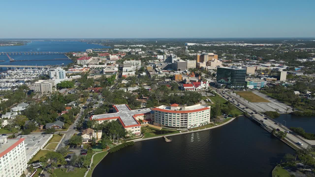 Aerial drone footage of Bradenton Florida showcasing the downtown skyline, riverfront, and bridges under clear blue skies. Wide Crane Up Right E